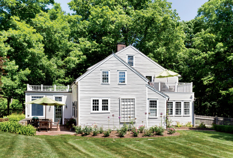 The house seen from the backyard, which includes tidy gardens of roses and peonies.