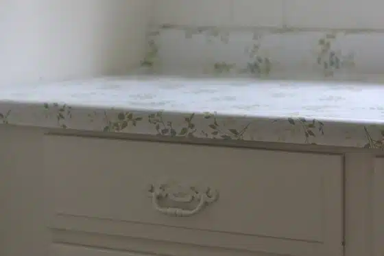 White cabinet with a floral-patterned countertop and a decorative handle.
