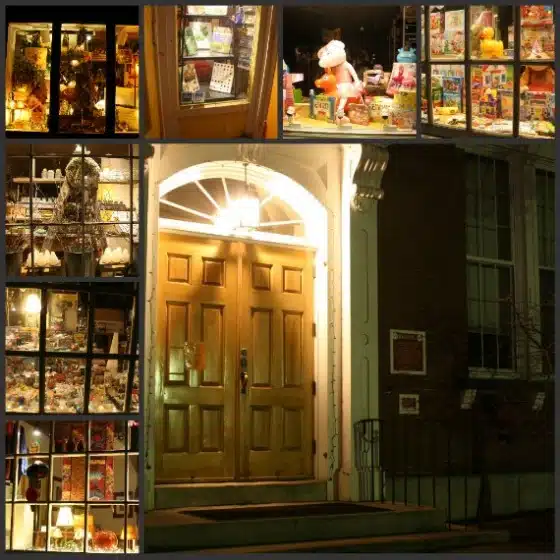 Collage of illuminated shop windows displaying toys and collectibles; in the center, a pair of wooden double doors under an archway, all seen at night.