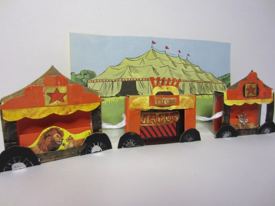 Three small matchboxes turned into a circus caravan.  A rectangle was trimmed from the center of each matchbox to create a 3D effect.