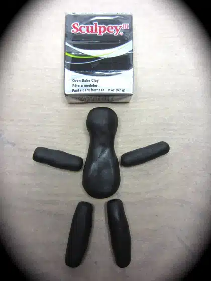 Shaping the clay into arms, legs and a torso with head