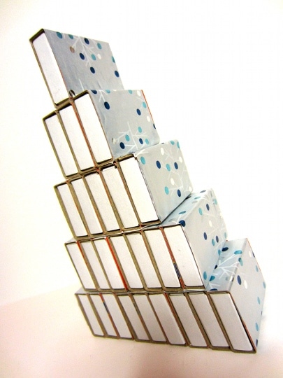 Rows of matchboxes are wrapped in paper. Then you glue the rows on top of each of each other to make a tree shape.