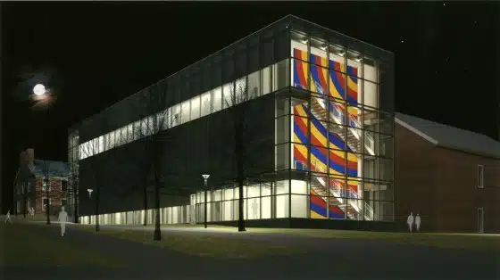 Modern glass building illuminated at night, showcasing large, colorful abstract artwork on its facade. Moon visible in the night sky.