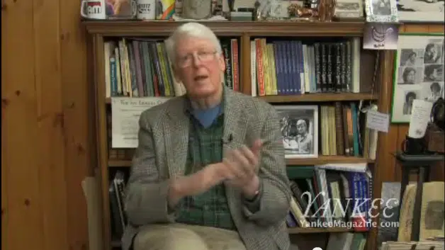 An elderly man with white hair sits in a room with bookshelves and framed photos, speaking. The words "YANKEE YankeeMagazine.com" are in the bottom right corner of the image.