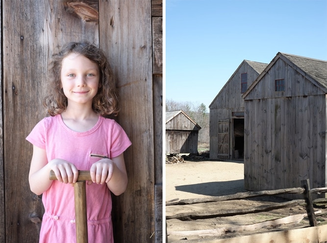 Ella holds a wooden handled shovel inside the barn at the Freeman Farm.  The barn was originally from Charlton, Massachusetts circa 1830-1850.