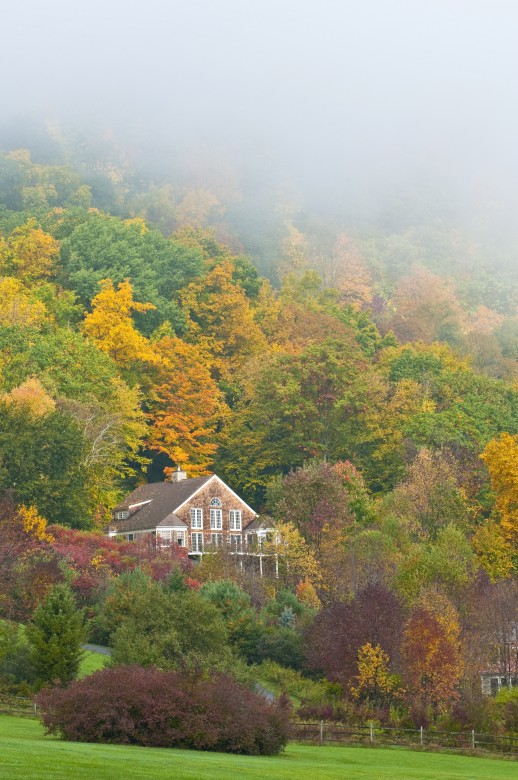 A shingled home nestled in foggy hills of the Berkshires.