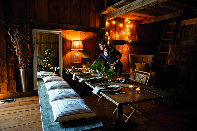 Inside the c. 1710 Captain Joseph Gould Barn (recon­structed on the grounds of the Parson Capen House) in Topsfield, Massachusetts, Jennifer Frost sets a festive  table before the Chive cele­bration for team members  and suppliers. Both house and barn are managed by the Topsfield  Historical Society.