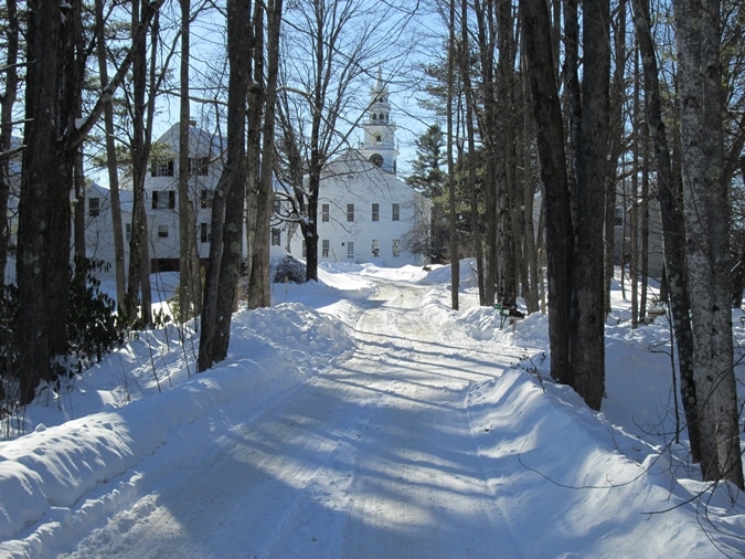 From the base of a freshly plowed Blackberry Lane, the Meetinghouse is ahead, and the former Cutter Tavern is on the right.