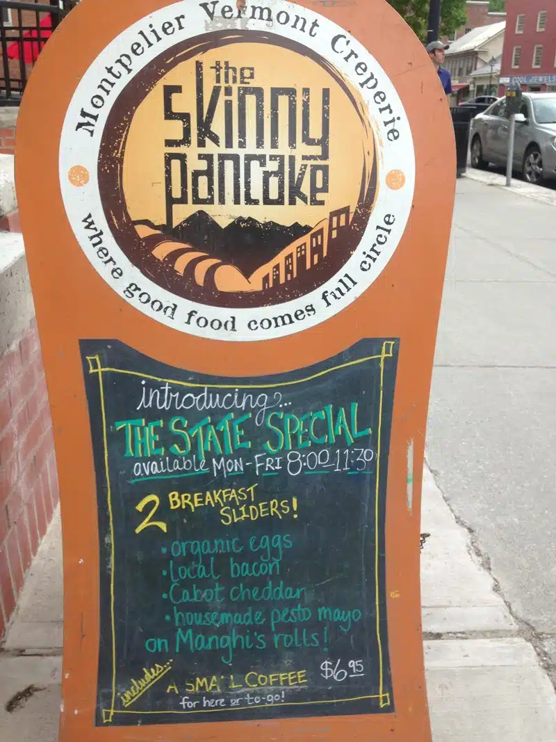 A sandwich board outside "The Skinny Pancake" advertises "The State Special" breakfast sliders with local ingredients, available Monday to Friday from 8:00 to 11:30, priced at $6.95 with a small coffee.