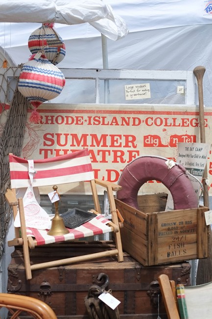 Rhode Island College Summer Theatre sign and beachy things displayed at Cozy Nook's booth.