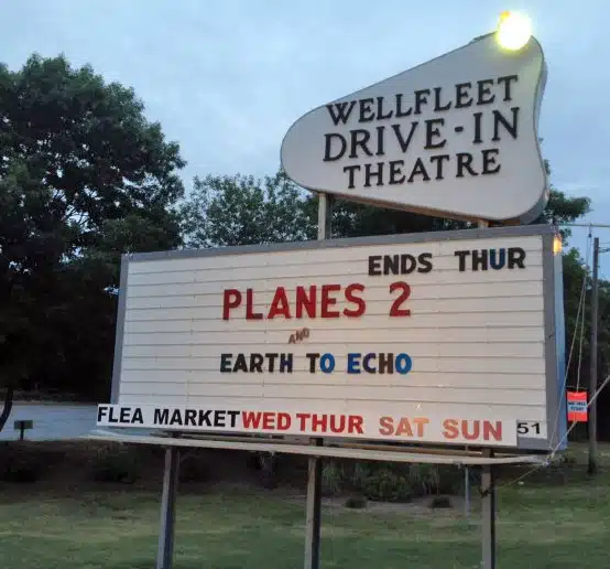 Drive-in theater sign with the showtimes for "Planes 2" ending Thursday, and "Earth to Echo." Flea market on Wednesday, Thursday, Saturday, and Sunday.