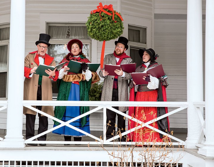 From the front porch of the Red Lion Inn, costumed carolers lead Stockbridge villagers in holiday song. 