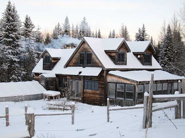 The Hewitt farmhouse amid snow-covered ever­greens.