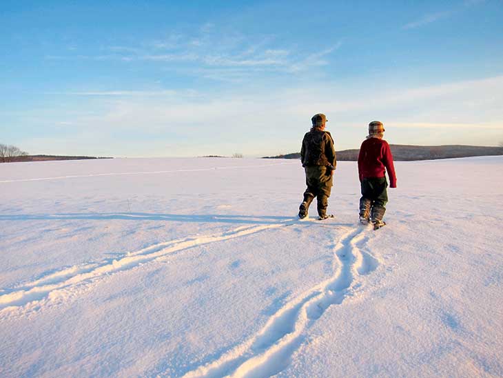 Fin (left) and Rye head out across a snowy field.