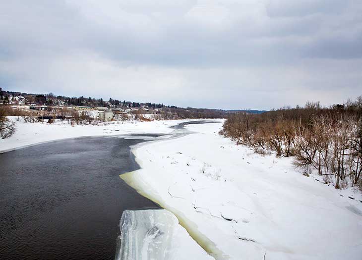 A view of Caribou from the bridge along Fort Fairfield Road, spanning the Aroostook River south of the city. “The bridge is high,” Laino observes, “and you really get a sense of the power of this water and the size of the ice that totally packs it, thawing throughout the season.”