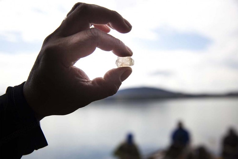 Penobscot archeologist Chris Sockalexis holds up a piece of quartz crystal he found on the beach during a break. “It was cool to see, among the crushed and water worn shale and rhyolite that was everywhere along the lake,” says Sockalexis. 