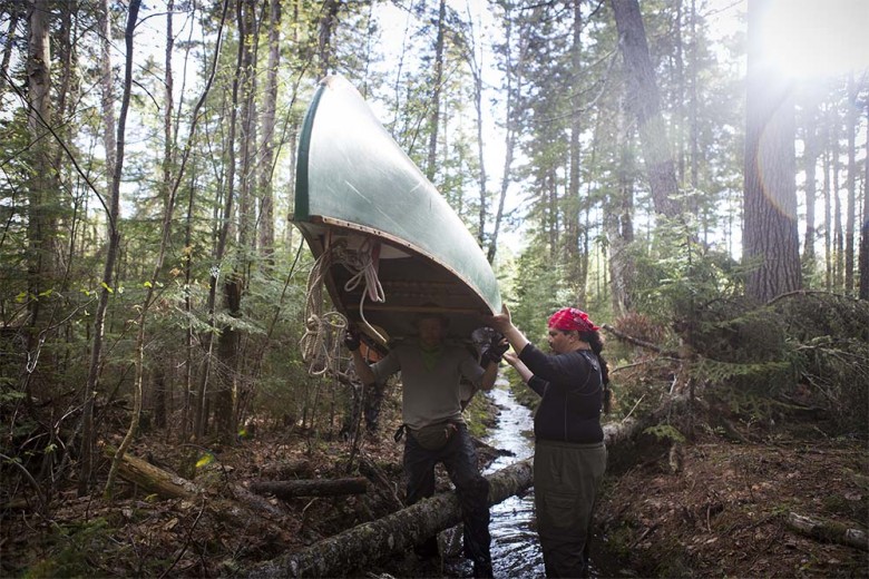 Photographer Jarrod McCabe carries his canoe, while Jason Pardilla assists him. In all, the carry consumed more than six hours and with all the back-and-forth, required some 15 miles of walking for some.  