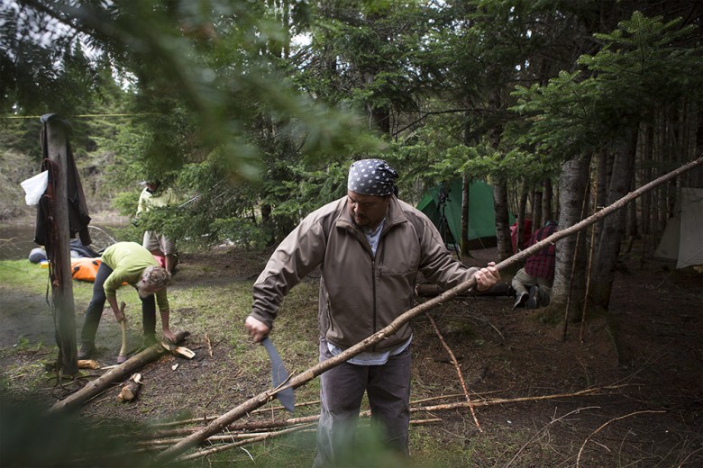 Jason Pardilla (foreground) limbs a felled tree for firewood on day three. Jason brought a machete on the journey, which proved to be a great tool for this kind of work. Behind him, Stan Tag sets up the chopping block. 