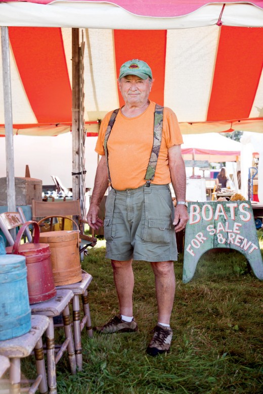 JON MAGOUN (Magoun Brothers) MIDWAY | ROUTE 20 (opposite New England Motel Food Court) “You can’t ever predict how the day’s going to be,” says Jon Magoun, a 30-year Brimfield veteran, whose card reads Ferocious Buyers & Sellers of Adirondack Boats. Behind him, vintage canoes and boats lie beached on green grass. “A few years ago we had four rainy days in a row,” he recalls. “Tommy Hilfiger comes through; we’re like drowned rats. He says, ‘I’ll take this side [of a double rack of canoes].’ A woman standing nearby gets nervous, and she says, ‘I’ll take this one.’ And then another woman comes along—I sold 10 canoes just like that.” Jon shakes his head: “In 20 minutes [the Hilfiger team] spent $23,000.” Jon’s booth is located front-and-center on Route 20. “That’s a Chestnut Canoe from the mid-’40s,” he notes as he points to a pretty little boat with its sail raised. “I bought it in West Bath, Maine, the other day.” Has he taken it out? “I like to canoe, but I never have enough time,” he says ruefully.