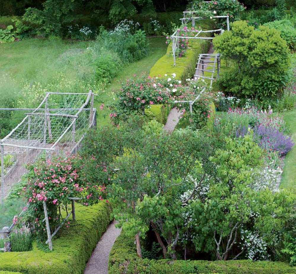 Arching over the gravel walkways of the main garden (seen here from the cupola of the house) are rose arbors supporting old climbers whose names were lost long ago.