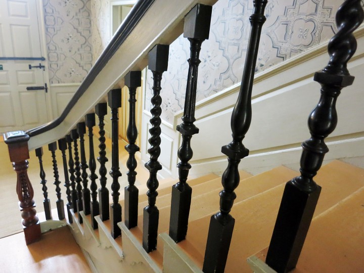 The stairway balustrade, which terminates at a beautifully carved newel post, is composed of balusters of three types, a pattern typical of Portsmouth. 