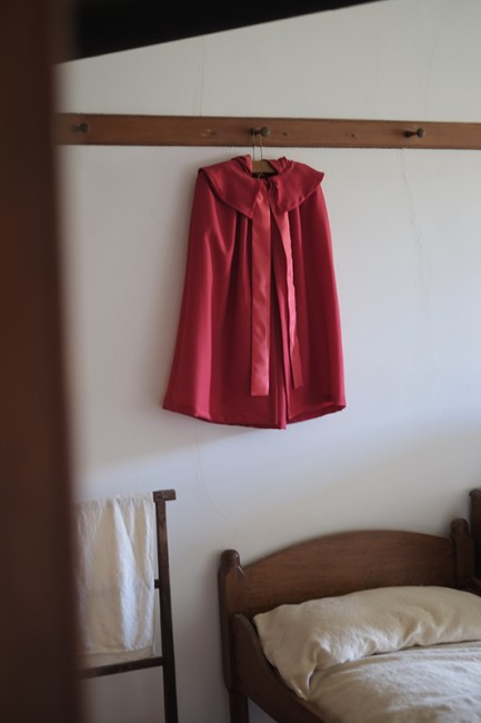 A red cloak in one of the bedrooms in the massive Brick Dwelling, c. 1830, that housed 100 shakers. 