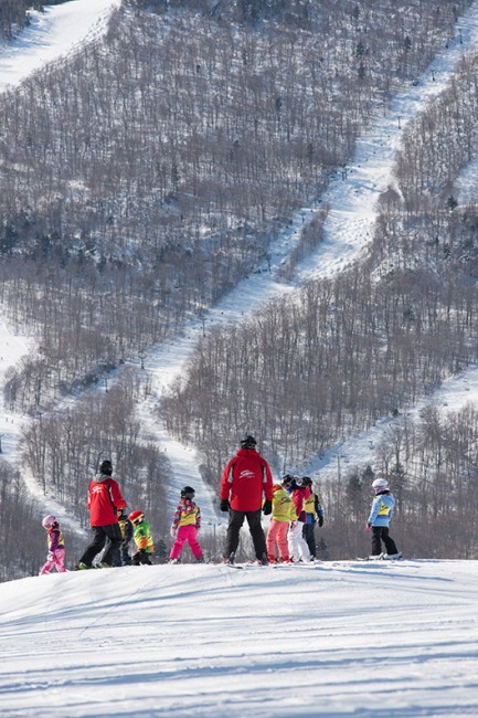 A group of young skiers learn the ropes with instructors in Stowe's signature red jackets.