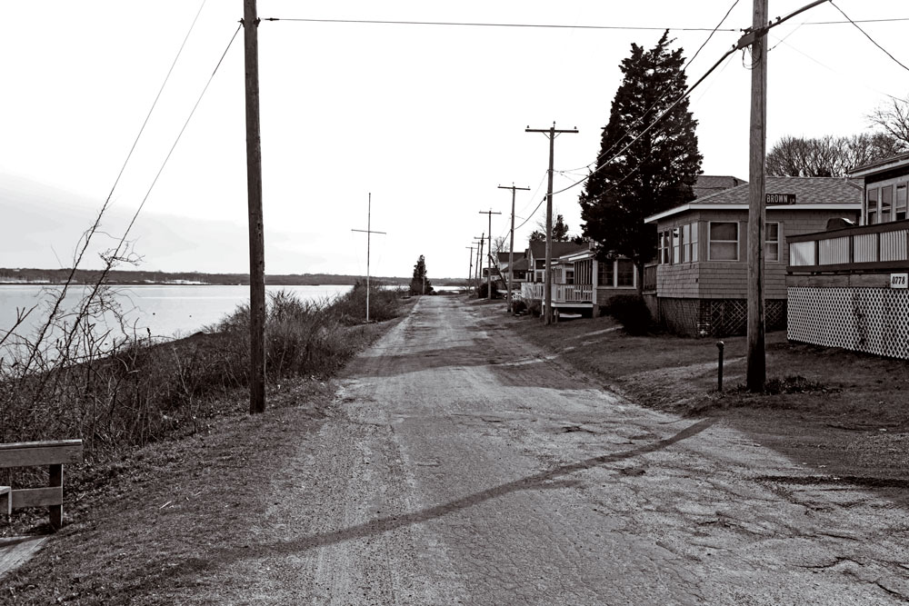 Narragansett Avenue, flanked by the East Passage, is lined with the modest homes and cottages that give the island a feel far different from summer island communities elsewhere. The island’s main route leads to the former naval munitions storage site, now in land conservation. Looking south is the Portsmouth shoreline. “My first impression when I arrived,” Cowie says, “was ‘There’s nobody here.’”