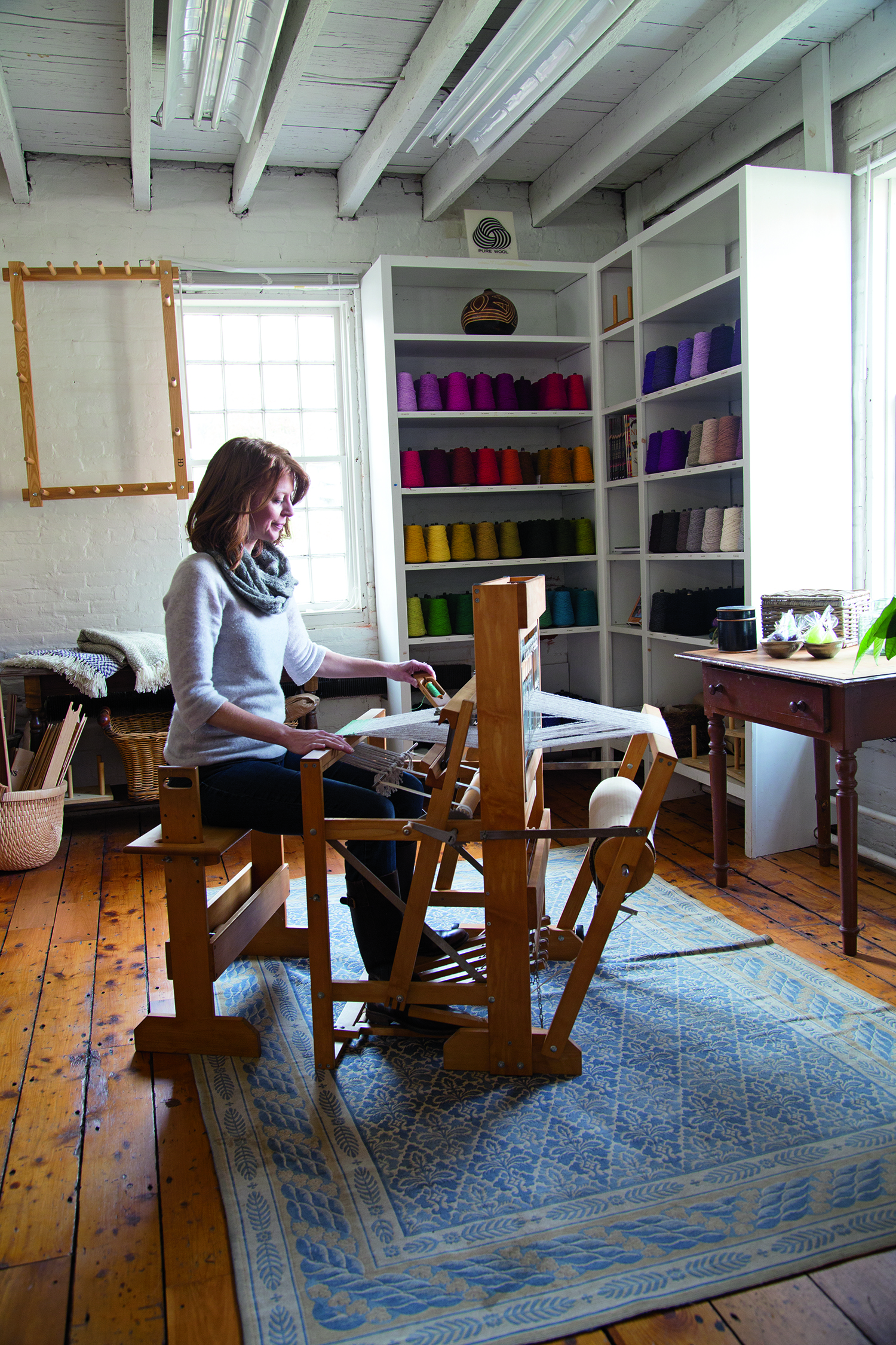 Sara Parker Strube works at a loom at Harrisville Designs, a restored mill complex in a historic New Hampshire village, offering classes and workshops in the textile arts, including weaving, knitting, and spinning.