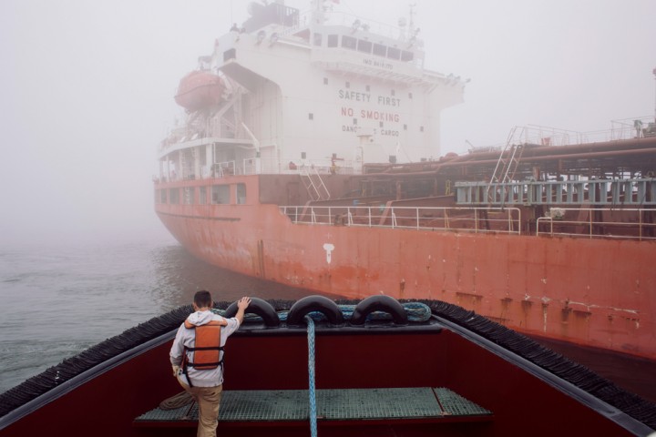With a thick fog reducing visibility, Marc Coffey, 22, a deckhand from Searsmont, Maine, works on a Fournier tugboat as it prepares to push an oil tanker into the harbor near Searsport. When the fog lifts, the tanker will be able to dock. 