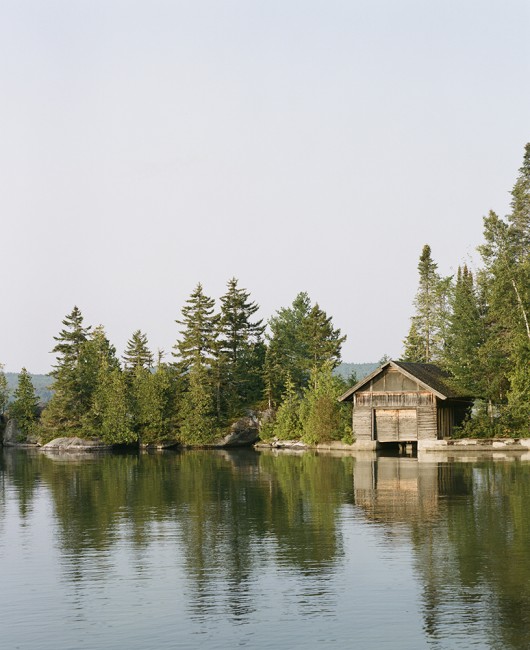 A lone boathouse blends into the woodsy landscape of Caspian Lake.