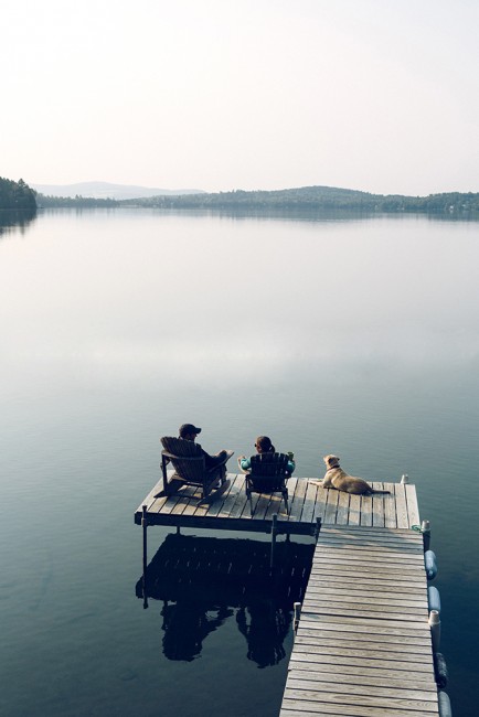 Brent and Maya McCoy relax with their dog LIttle on the Mitchell family dock overlooking Caspian Lake.