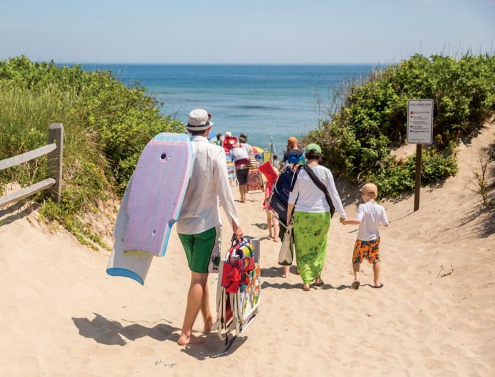 Trekking down to Coast Guard Beach in Eastham. “We have a system of saying in the morning, ‘Left or right?’ and someone chooses,” Dom says. “Today we’re going to go left or right of the boardwalk, and whoever gets there first sets up the spot; the others arrive at their own pace.” 