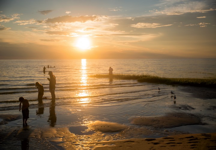 Playing in the shallow bayside water at Skaket Beach in Orleans as the sun sets over Cape Cod Bay.