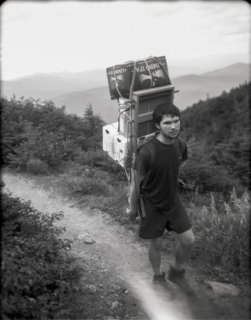 A "croo" member from Madison Spring Hut carries a heavy load of fresh food up the trail.