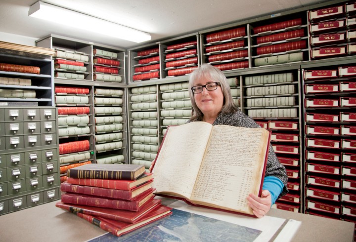 Wilmington Town Clerk Susan Haughwout, in the archive vault at the town offices. Haughwout led a small team of volunteers in the hours before the storm to move key town documents, like these land-record volumes, out of the flood zone to an upstairs floor.