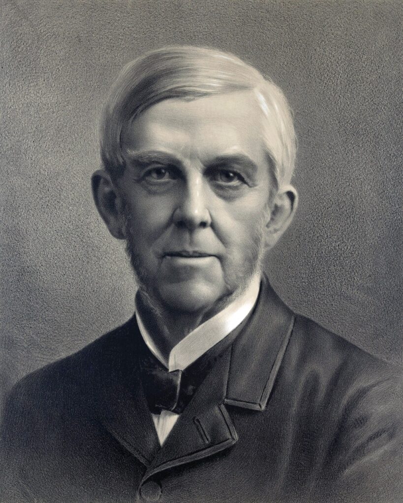 New England First Families. Black-and-white portrait of an older man with short hair, sideburns, and a suit with a bow tie.