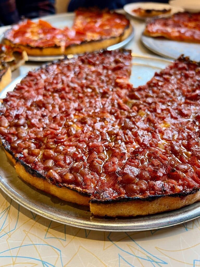 A trio of South Shore bar pizza pies from Lynwood. The Bean Special comes topped with Boston baked beans, onion, and salami.