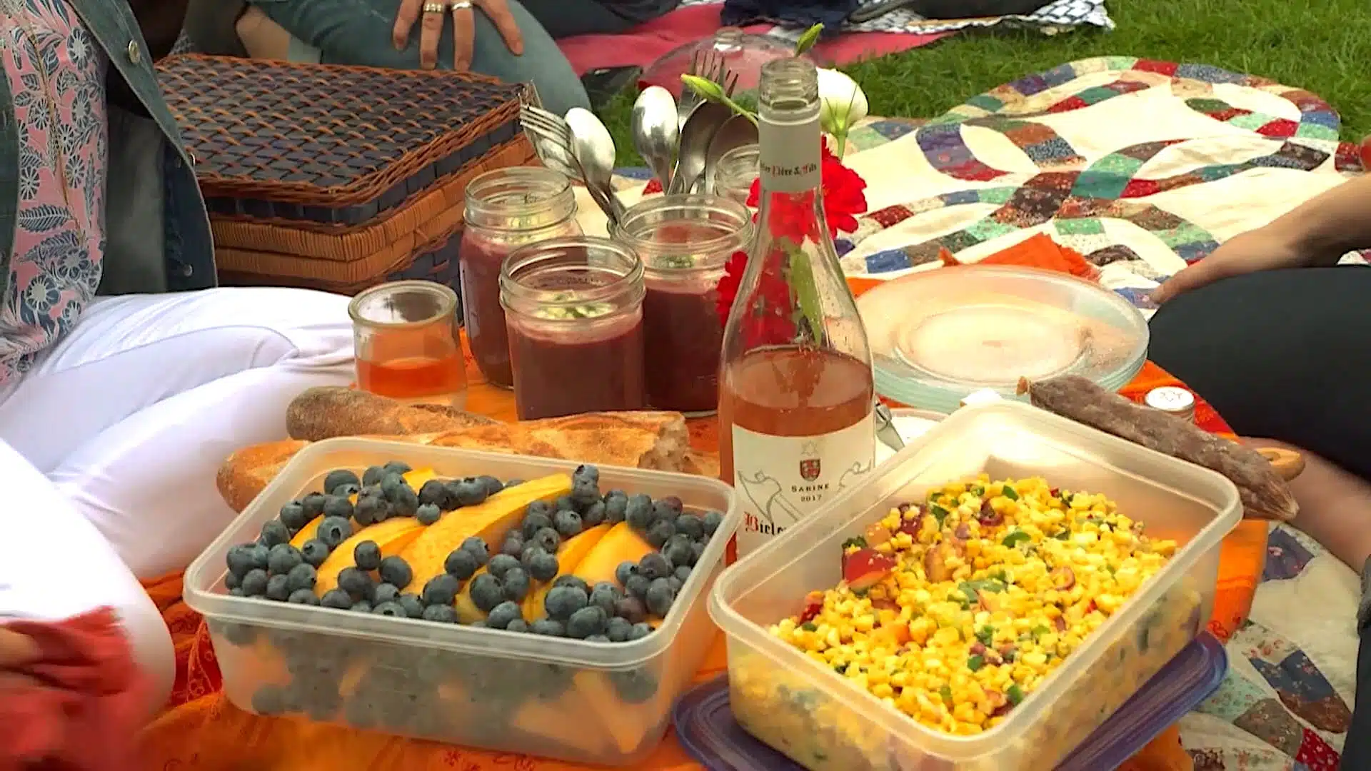 picnic with blueberries, corn salad, and drinks.