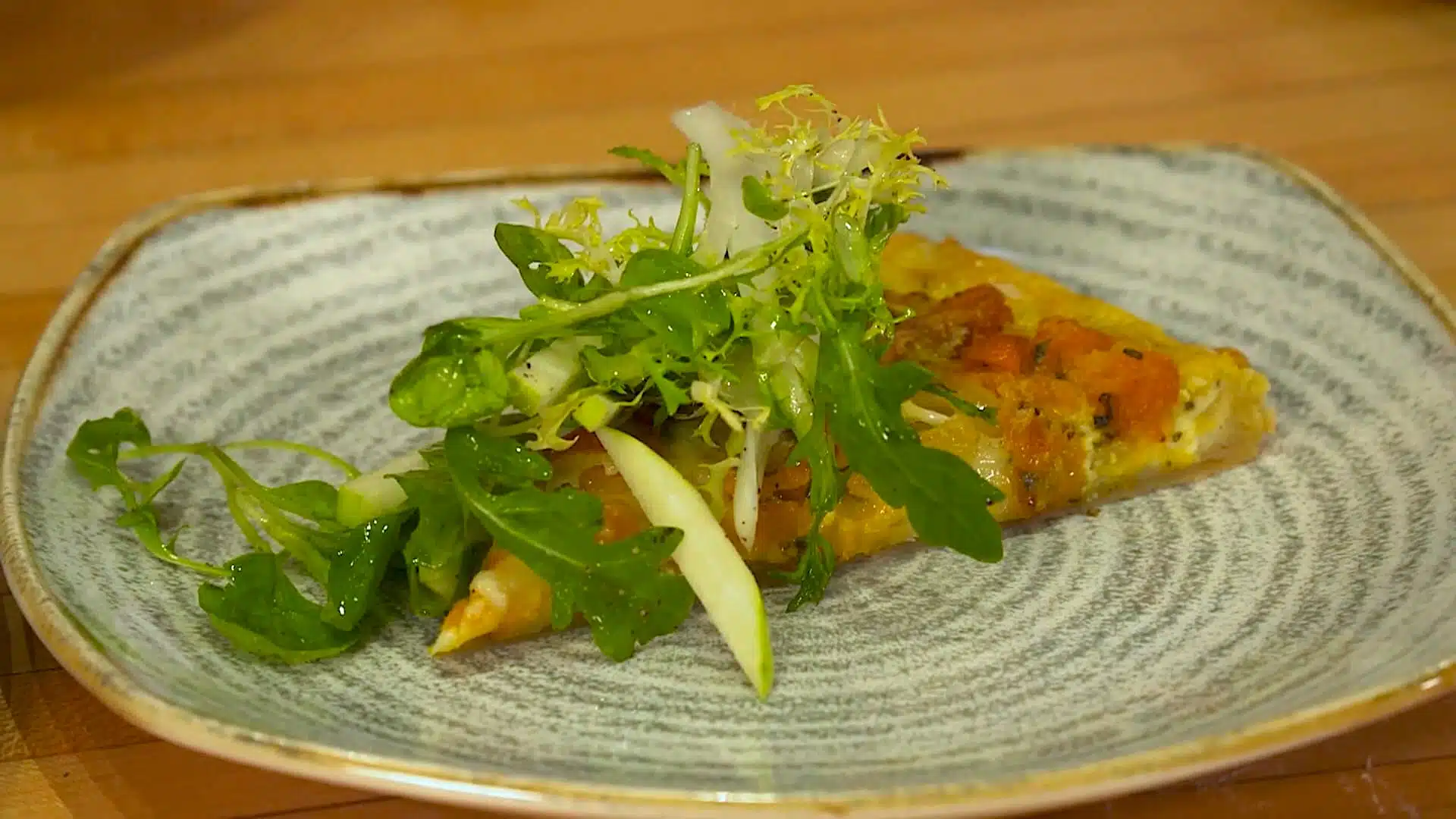 squash and cheese tart with a bright salad on top.