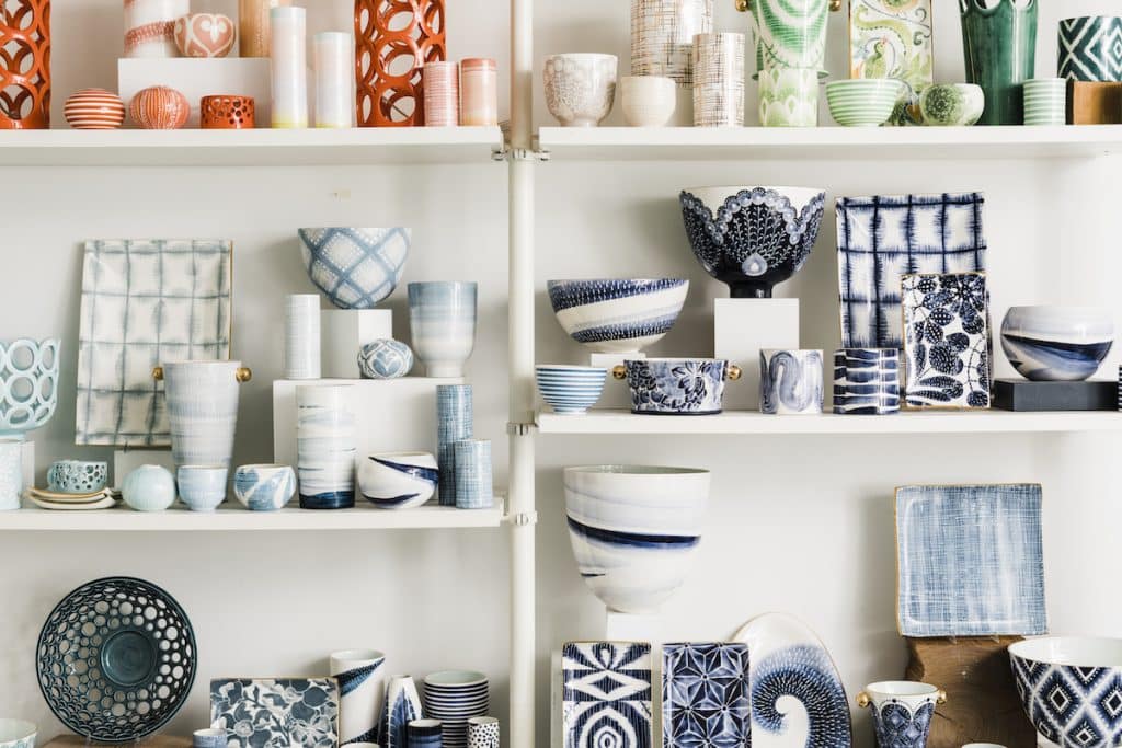 Shelves displaying a variety of colorful ceramic vases, bowls, and plates in intricate patterns and designs.