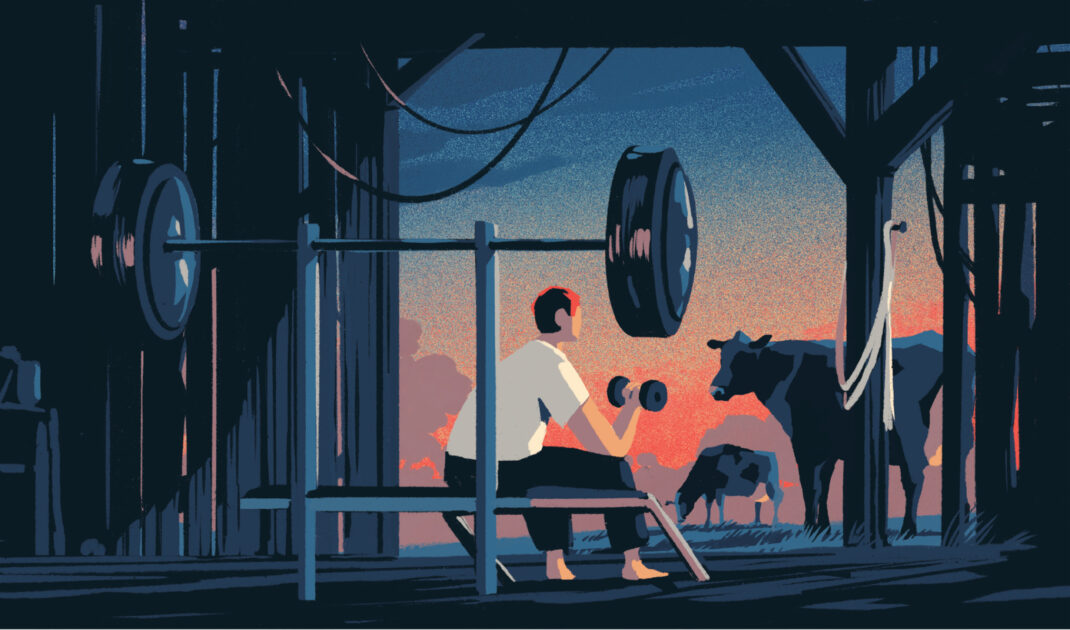 A person lifts a dumbbell while sitting on an outdoor bench press setup in a barn, with cows grazing and a sunset in the background.