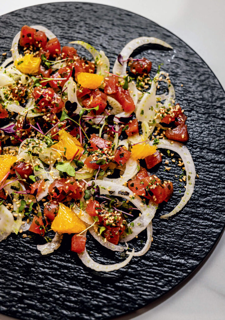 The 2025 Yankee Food Awards. A black plate with sliced fennel, diced tuna, orange segments, herbs, and seeds artfully arranged.