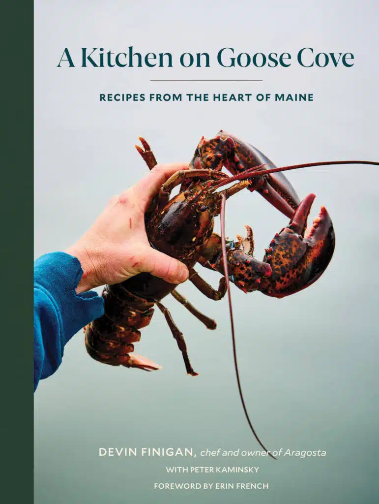 Book cover shows a hand holding a large, live lobster below the title "A Kitchen on Goose Cove."