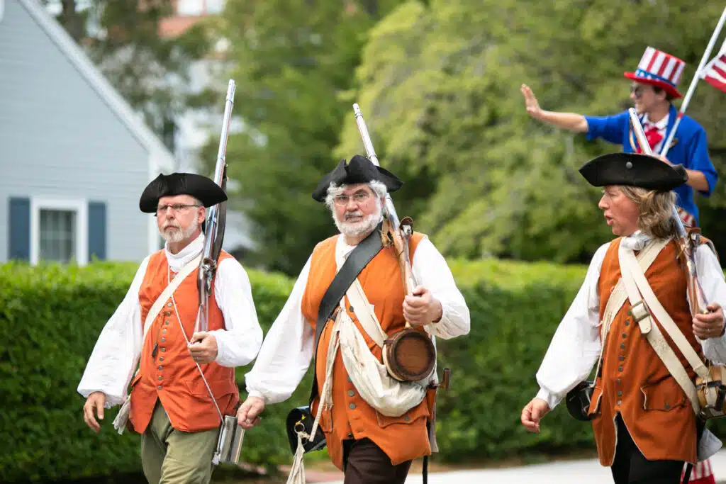 Newburyport, MA. Three men in colonial costumes march with muskets.