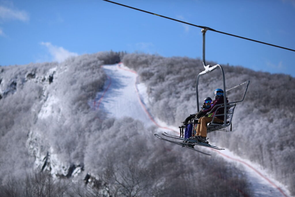 Two people ride the Skiway chairlift in New Hampshire.