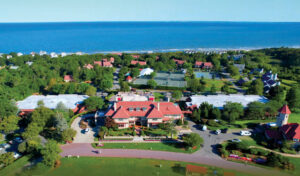 Aerial view of Ocean Edge Resort on Cape Cod with red-roofed buildings, green lawns, and the ocean in the background.