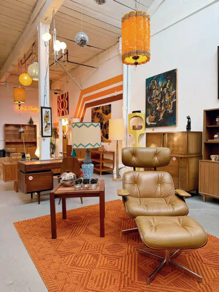 A retro living room with mid-century modern furniture, orange rug, and vintage decor items.