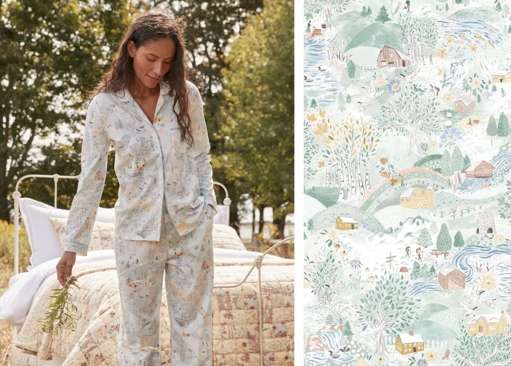 Woman in patterned pajamas stands by a bed outdoors; pajama fabric features a whimsical, scenic print.