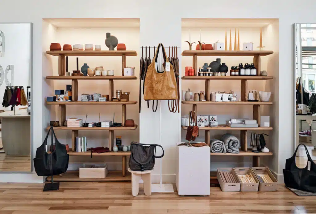 Made in New England: Rough & Tumble Bags in Portland, Maine. Modern store with shelves displaying home decor, leather bags, ceramics, and neatly arranged accessories.